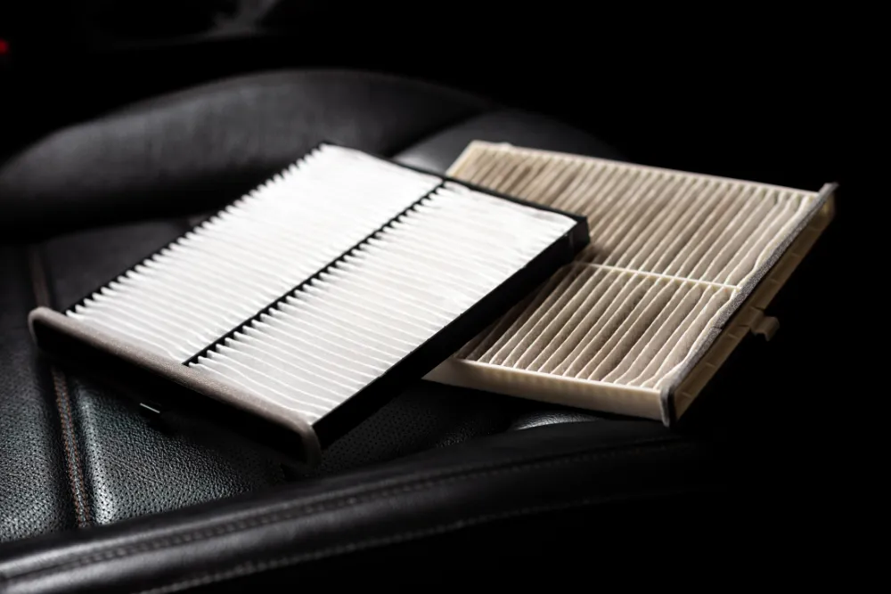 Cabin air filter replacement in Sparta, IL by Charlie's Tire & Automotive. Image of new and used cabin air filters placed on a vehicle seat. Highlighting improved interior air quality, HVAC efficiency, and a healthier, more comfortable driving experience.
