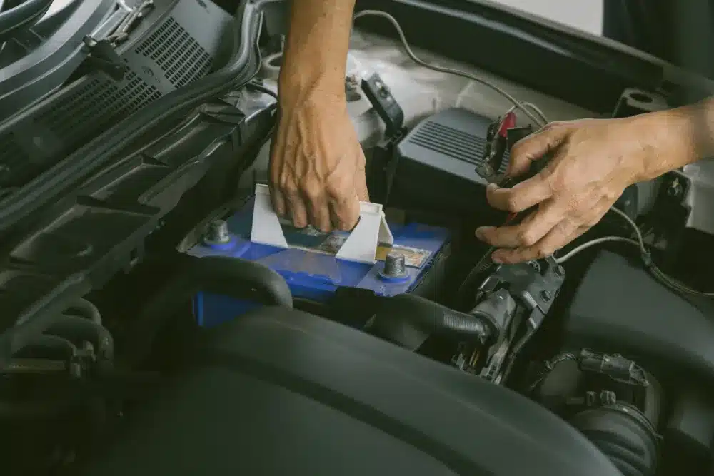 Battery service, auto repair in Jackson, MO by Charlie’s Tire and Automotive. Image of a technician installing a vehicle battery, highlighting reliable starts, proper electrical performance, and dependable service to keep your car running strong.