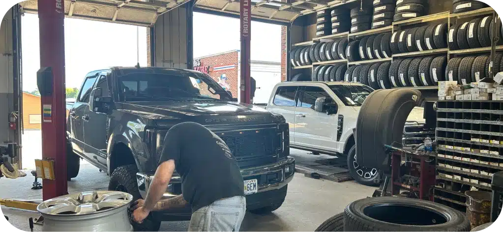 Auto Repair Services In MO & IL At Charlie’s Tire and Fast Lube. Two trucks in a tire shop
