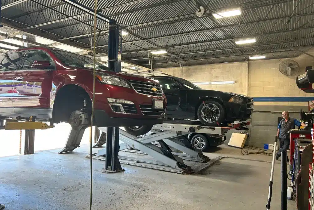 Vehicle maintenance, auto repair in Dexter, MO by Charlie’s Tire and Automotive. Image of multiple vehicles lifted on service racks inside a professional shop, with a technician performing inspections and repairs to ensure safe, reliable driving performance.