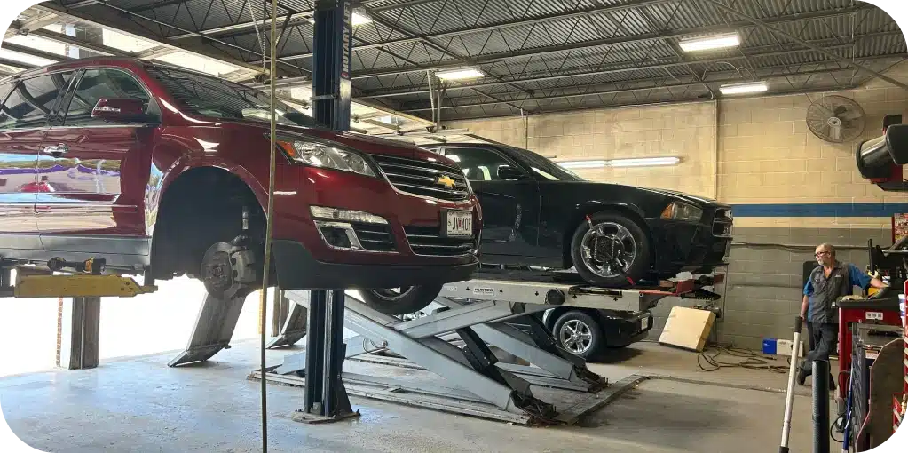 Vehicles We Service in Missouri & Illinois At Charlie’s Tire and Fast Lube. Two cars on hydraulic lifts in garage