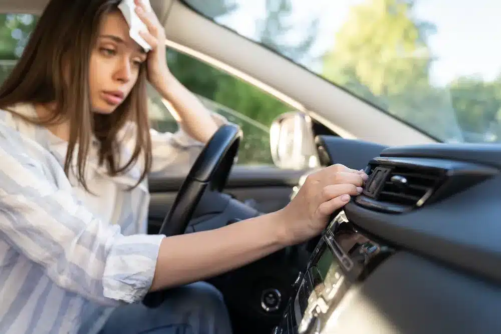 Cooling System Service in Missouri by Charlie’s Tire and Automotive, a woman in her car sweating from a failed A/C