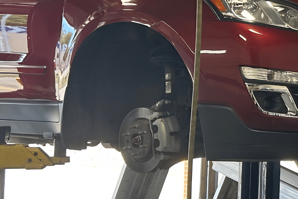 Brake Pad and Rotor Replacement in Sparta, IL At Charlie’s Tire and Automotive. Vehicle elevated on a lift undergoing summer brake pad and rotor replacement.