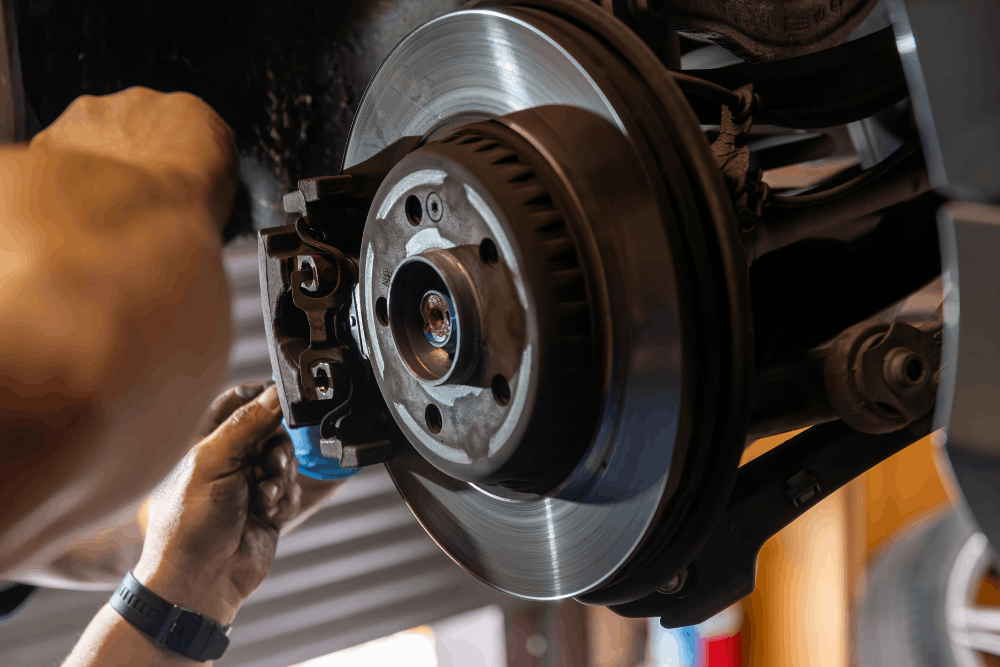 Brake inspection, auto repair in Jackson, MO at Charlie’s Tire and Automotive. Image of a technician inspecting a brake rotor and caliper assembly to support safe, reliable braking.