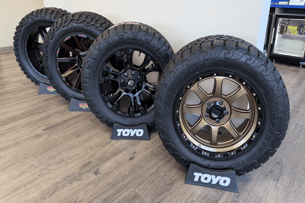New tire sales and installation with Charlie's Tire and Automotive locations in Missouri and Sparta, Illinois. Image of 4 brands of tires and wheels displayed in location office space.